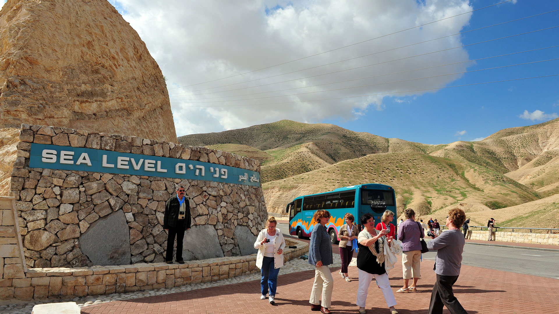 Lionsgate Travel group posing by the sea level sign on their way to the Dead Sea, the lowest place on earth.